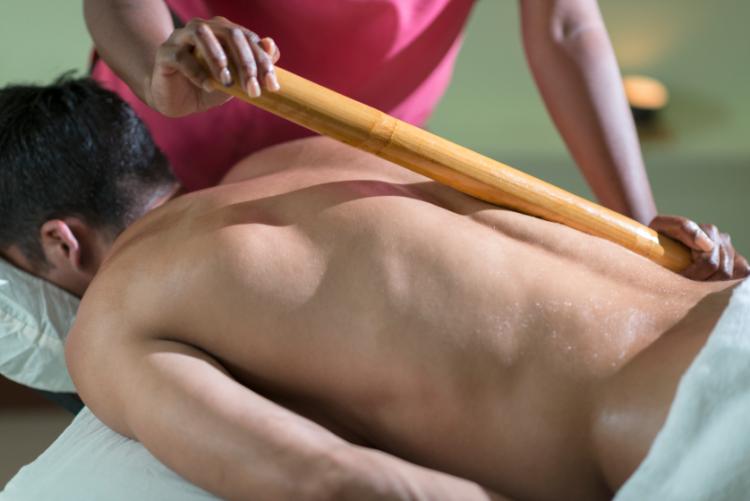 getting massage with bamboo stick